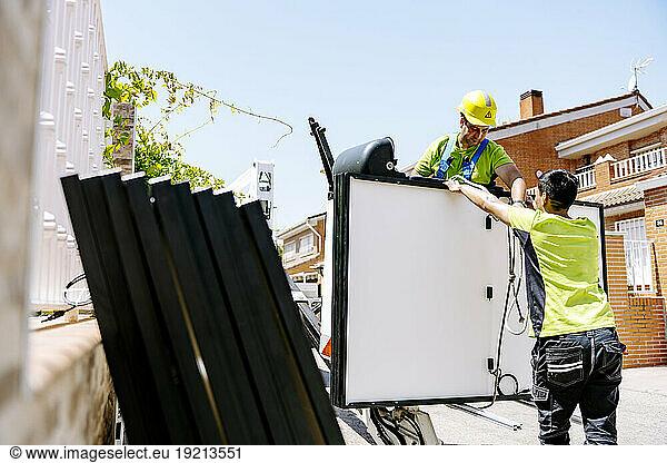 Engineers working with solar panels on sunny day at site