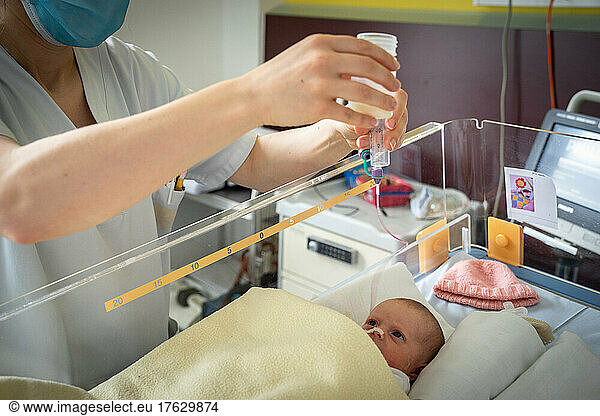 Enteral feeding of an infant by a midwife in a hospital center.