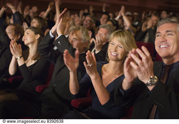 Enthusiastic audience clapping in theater