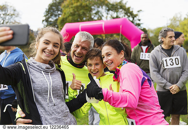 Enthusiastic family runners taking selfie at charity race