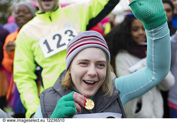 Enthusiastic woman with medal cheering at charity race