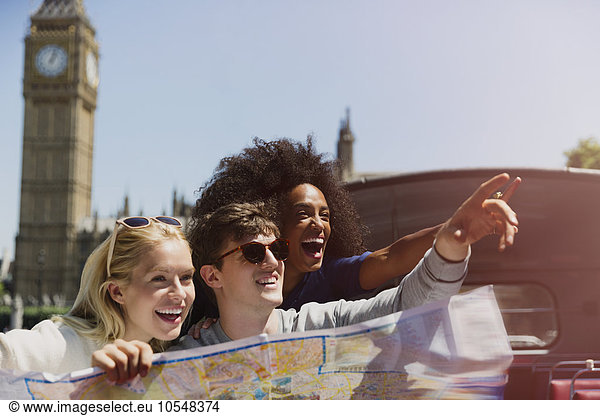 Enthusiastische Freunde mit Karte unter dem Big Ben-Uhrturm in London