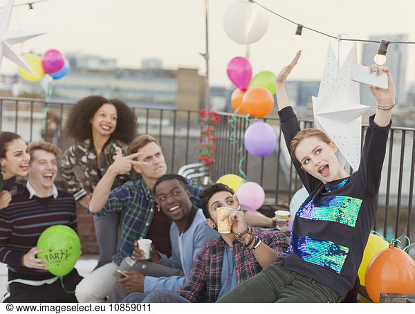 Enthusiastische junge erwachsene Freunde nehmen Selfie auf der Dachparty