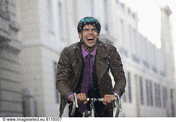 Enthusiastischer Geschäftsmann beim Radfahren im Regen