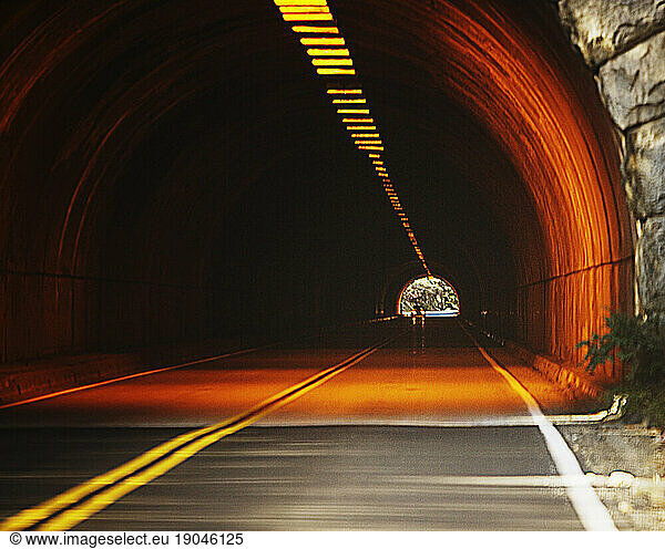 Entrance to a illuminated road tunnel. Photo manipulated.