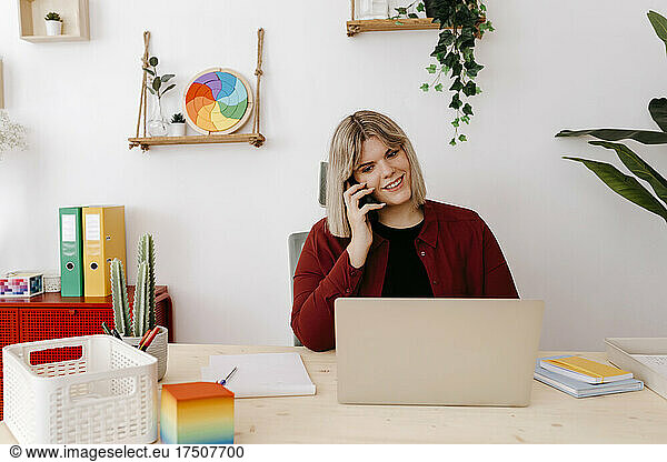 Entrepreneur talking on smart phone at desk in office