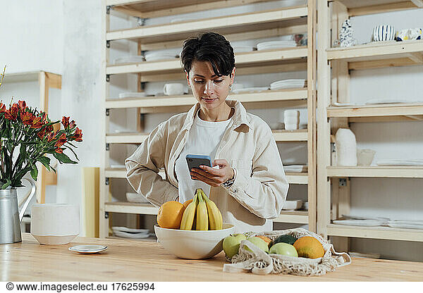 Entrepreneur using mobile phone in ceramics workshop