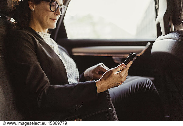 Entrepreneur using mobile phone while sitting in car