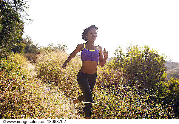 Entschlossene Frau joggt auf Grasfeld