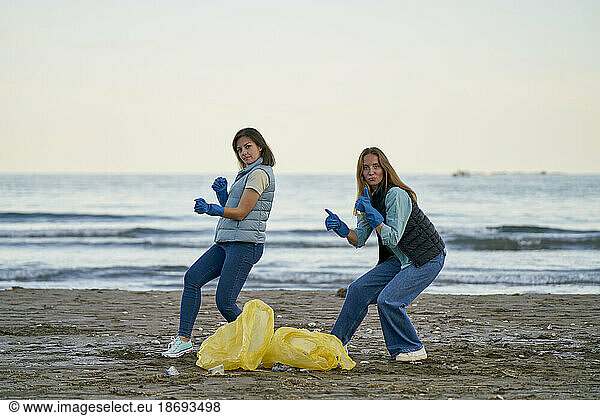 Environmentalists dancing by plastic bags at beach