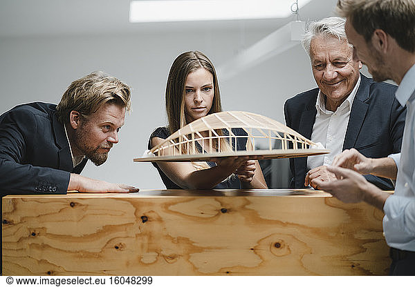 Erfolgreiche Geschäftsleute betrachten das architektonische Modell im Büro