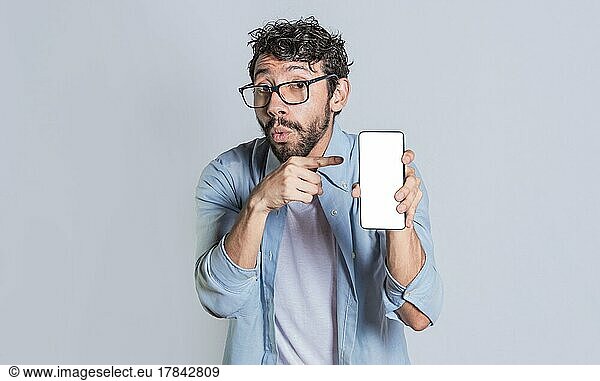 Erstaunter Mann zeigt Handy-Bildschirm  Schockierte Person zeigt und zeigt auf sein Smartphone-Bildschirm  Erstaunte Menschen zeigen und zeigen auf leeren Handy-Bildschirm