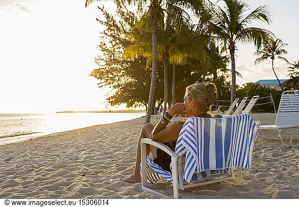 Erwachsene Frau sitzt im Urlaub im Strandkorb