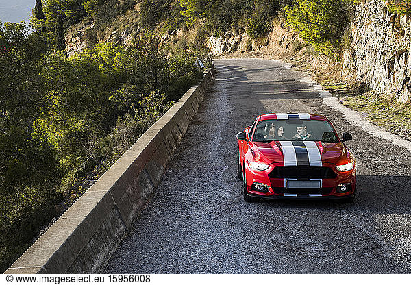 Erwachsenes Paar fährt roten Sportwagen  Spanien