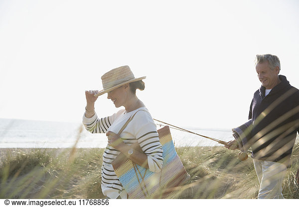 Erwachsenes Paar mit Angelrute im sonnigen Sommerstrandgras