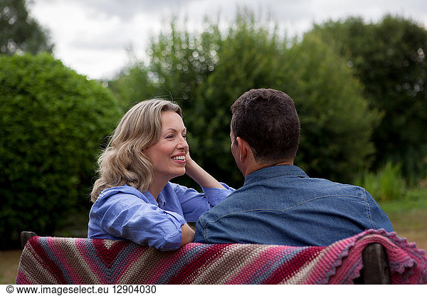 Erwachsenes Paar sitzt auf Gartenbank