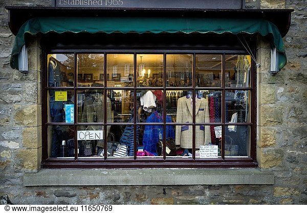 Escaparate de una tienda de ropa tradicional inglesa con el cartel de 'OPEN'. Grassington  Yorkshire Dales  North Yorkshire  Skipton  UK.