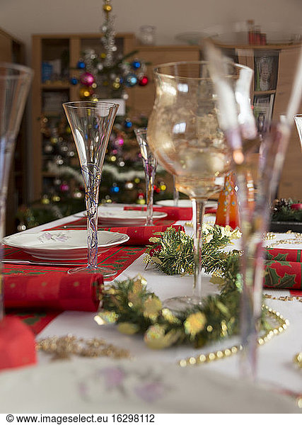 Esstisch mit Gläsern  Geschirr  Servietten und weihnachtlicher Dekoration