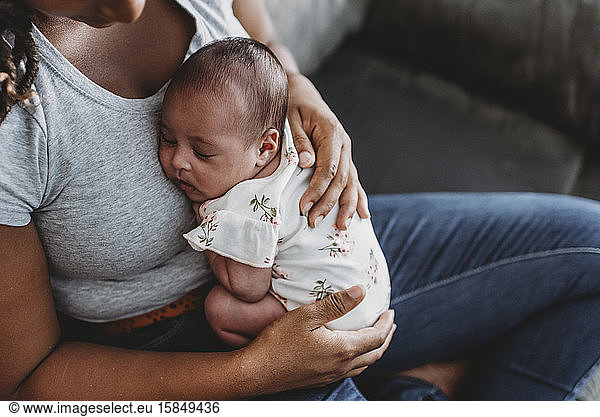 Ethnic mother cradling multiracial sleeping infant