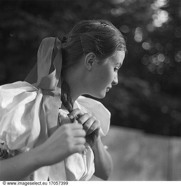 Ethnology / Slovakia. Young dancer from a Slovakian folk dance group braiding her hair. Photo  c. 1965.