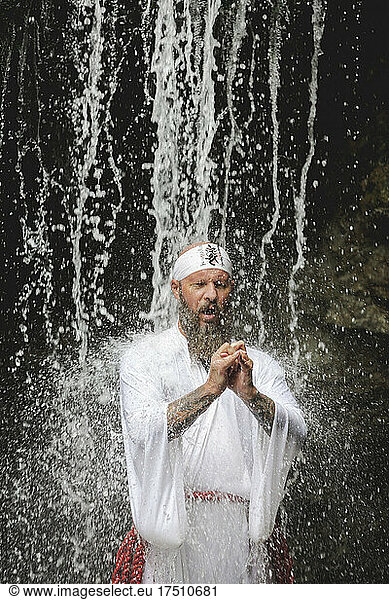 European yamabushi monk doing takigyo waterfall meditation