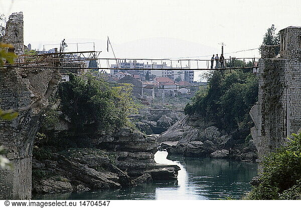 events  Bosnian War 1992 - 1995  Mostar  provisional suspension bridge over river Neretva  1994  Bosnia-Herzegovina  Bosnia - Herzegovina  destruction  destroyed bridge  flag  Yugoslavia  Yugoslav Wars  Balkans  conflict  people  1990s  90s  20th century  historic  historical