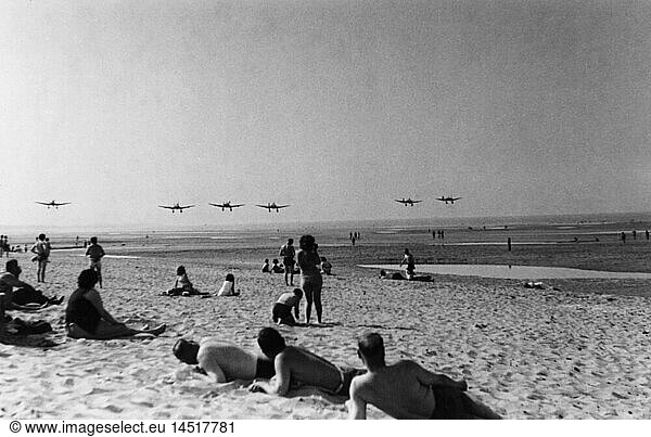events  Second World War / WWII  aerial warfare  aircraft  a squadron of dive bombers Junkers Ju 87 B in low level flight over a beach  probably France  summer 1940  Ju87  Ju-87  Stukas  Stuka  German occupation  airplanes  aeroplanes  planes  Battle of Britain  1940s  40s  20th century  historic  historical  military  Third Reich  Wehrmacht  Germany  sunbathing  sunbath  sun bath  people