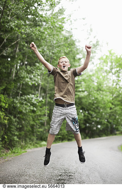 Excited boy jumping in mid-air