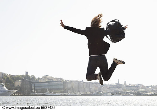 Excited business woman jumping in air