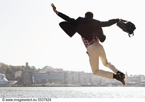Excited businessman jumping in air