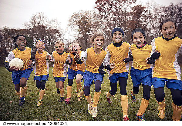 Excited female soccer team enjoying on playing field