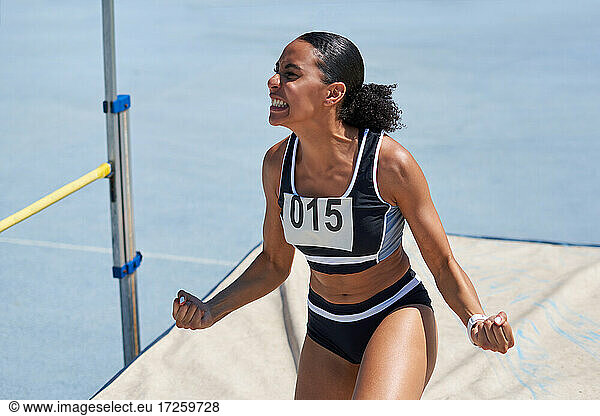 Excited female track and field athlete celebrating high jump