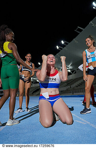 Excited female track and field athlete celebrating victory after race