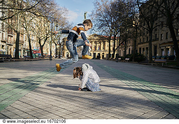 Excited girl and boy playing on street