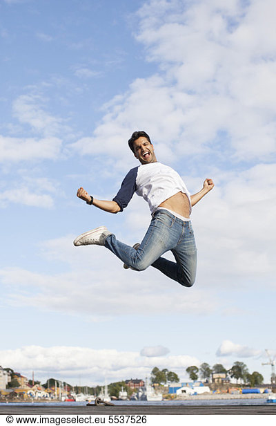 Excited young man jumping in air