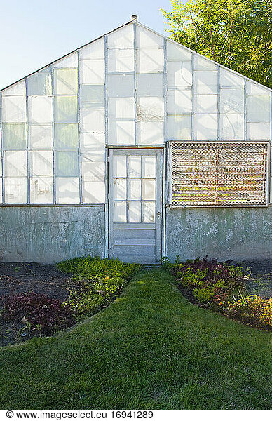 Exterior of dilapidated abandoned greenhouse.