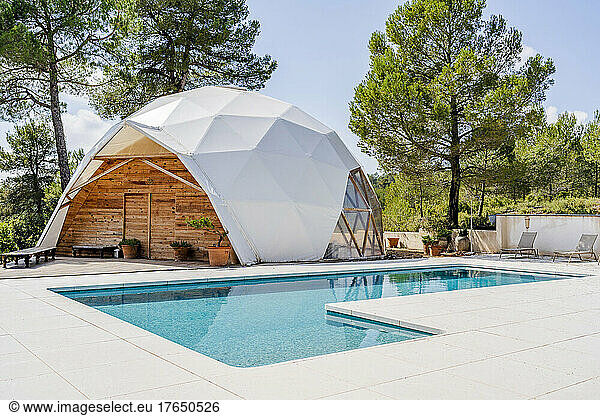 Exterior of dome shaped room by swimming pool at hotel on sunny day