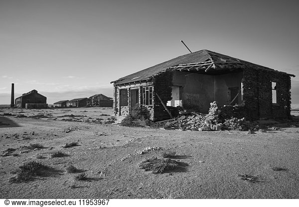 Exterior view of abandoned buildings in a desert.