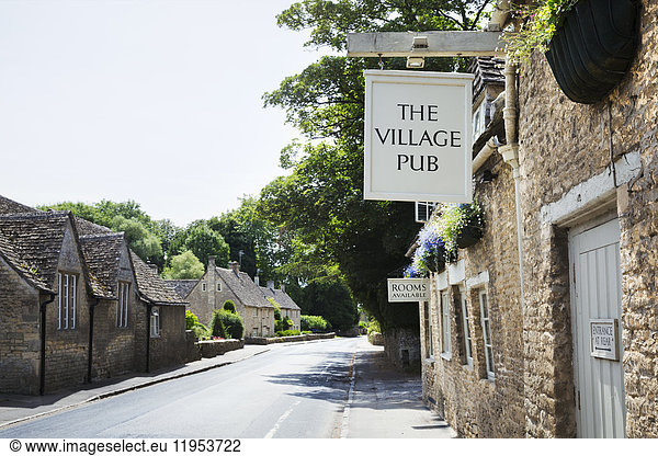 Exterior view of village pub with sign advertising available rooms.
