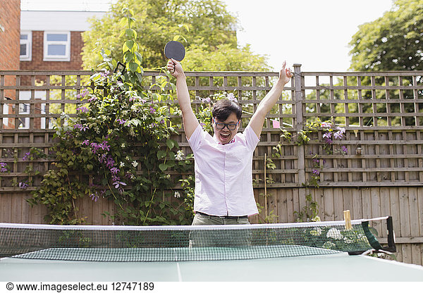 Exuberant man playing table tennis  celebrating
