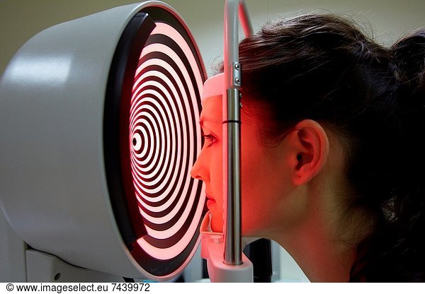 Eye examination Patient having a corneal topography measurement made of her eye The device at centre projects bright rings onto the eye  which are reflected in its surface By studying the reflection  an accurate model can be built up of the shape of her cornea The cornea is the front part of the eye that covers the iris and pupil It is responsible for the majority of light focusing  with only fine focusing being done by the lens Defects in the shape of the cornea can lead to a wide range of focusing disorders These can be treated by surgery or by the wearing of tailored contact lenses or spectacles Ophthalmology  Hospital Donostia  San Sebastian  Gipuzkoa  Basque Country  Spain