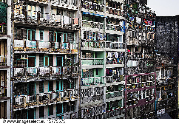 Facade of rows of run down apartment houses with washing hanging on balconies.