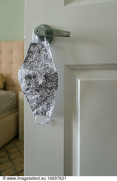 Face mask hanging on doorknob coronavirus protection