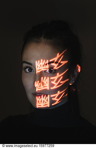 Face of beautiful woman covered in light patterns