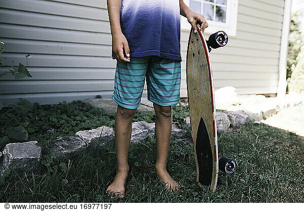 faceless image of child holding skateboard