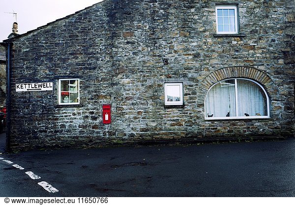 Fachada de una casa con ventanas  un buzon de Post Office  cartel indicador de direccion 'Kettlewell'. Gayle  Hawes  North Yorkshire  Yorkshire Dales  Skipton  UK.