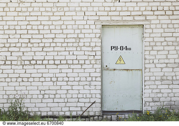 Factory Entrance With a Warning Sign