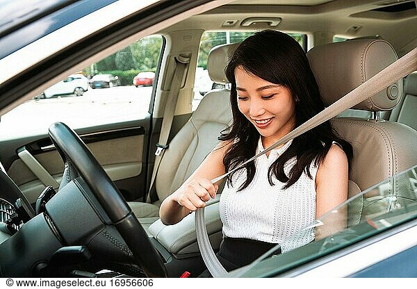 Fahrende junge Frau  die einen Sicherheitsgurt trägt