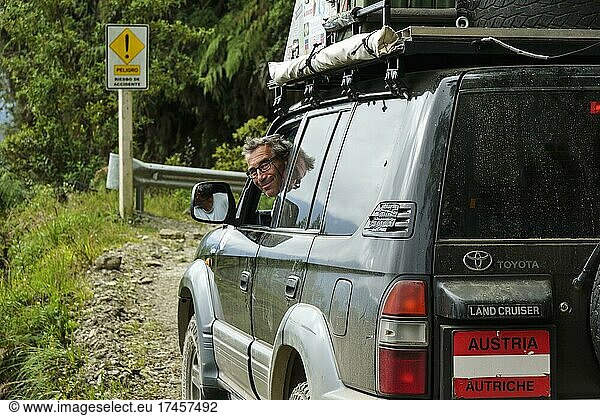 Fahrer lächelt aus einem Geländewagen  Toyota Land Cruiser  auf der Todesstraße  Camino de la Muerte  Departement La Paz  Bolivien  Südamerika