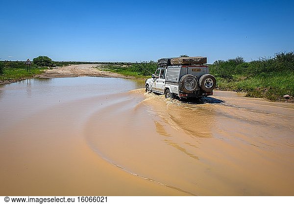 Fahrt durch eine Pfütze in der Kalahari-Wüste  Namibia.